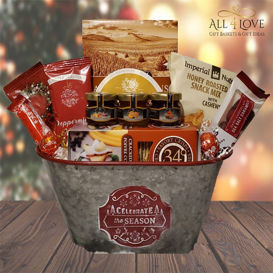 Silver metallic basket with seasonal message full of assorted chocolate, jam, nuts and treats