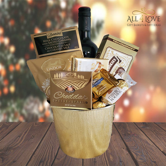 Golden bucket with gold packaged treats and wine bottle