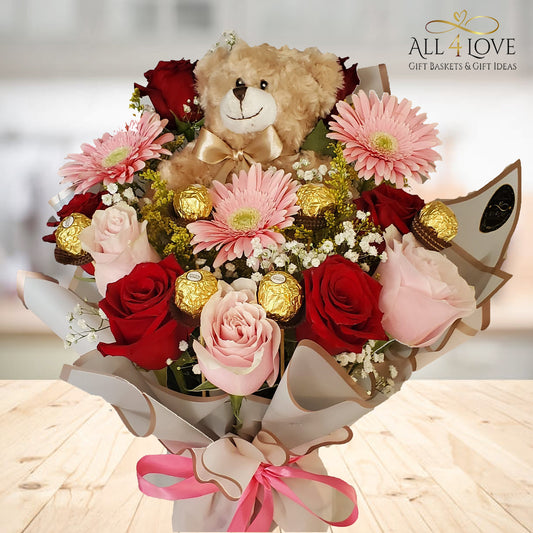 Teddy bear nestled in colourful flowers with chocolate